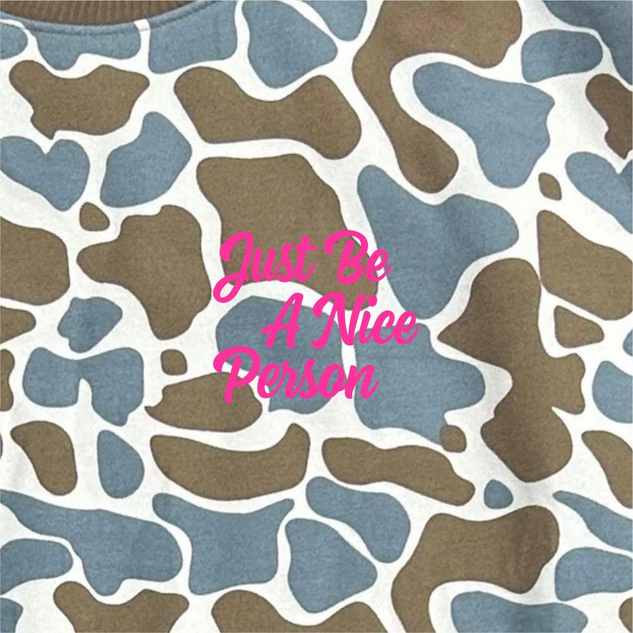Camouflage pattern with 'Just Be A Nice Person' text in pink on a white background