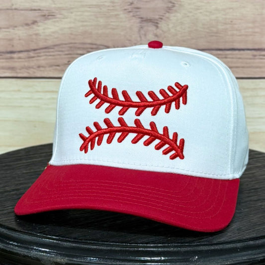 Baseball cap with red stitching on a wooden surface