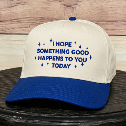 Cream and royal blue embroidered baseball hat featuring "I Hope Something Good Happens to You Today" inspirational quote, structured trucker cap with premium embroidery and curved blue brim.